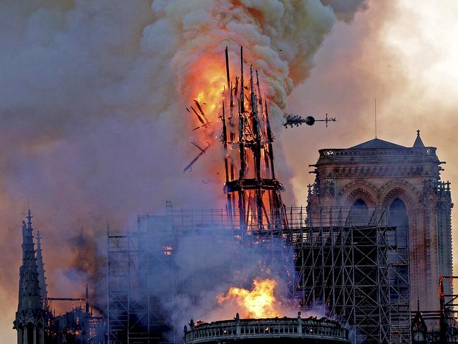 The steeple collapses as smoke and flames engulf the Notre-Dame Cathedral in Paris on April 15, 2019. - A huge fire swept through the roof of the famed Notre-Dame Cathedral in central Paris on April 15, 2019, sending flames and huge clouds of grey smoke billowing into the sky. The flames and smoke plumed from the spire and roof of the gothic cathedral, visited by millions of people a year. A spokesman for the cathedral told AFP that the wooden structure supporting the roof was being gutted by the blaze. (Photo by Geoffroy VAN DER HASSELT / AFP)