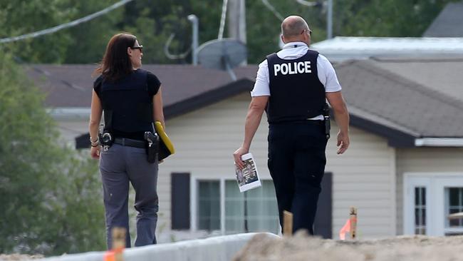 Police going door-to-door in Gillam with photos of the alleged killers. Picture: Clint Brewer