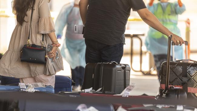 Expatriates collect luggage from their Delhi flight after a Qantas flight carrying returning Australians touched down at RAAF Base Darwin, with passengers transported to Howard Springs Quarantine Facility. ADF Supplied pictures