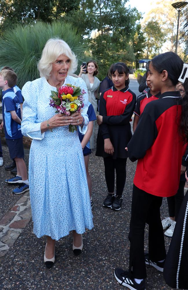 Queen Camilla receives flowers from local school children at the Australian National Botanic Gardens. Picture: Chris Jackson/Getty