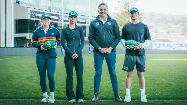 Business consumer manager Jesse O'Hara with three of the Tasmania Devils young members as it was announced the club hit 210,000 members. Picture: AFL Tasmania