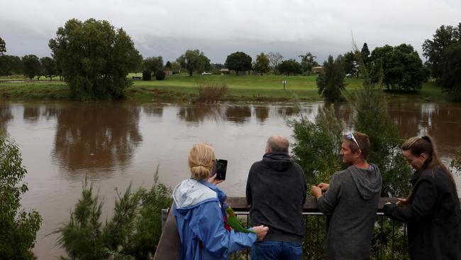 People look out to a swelling Hawkesbury with residents on alert. Picture: Damian Shaw