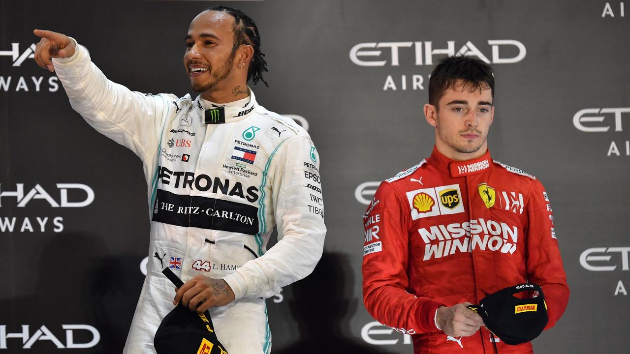 Mercedes' Lewis Hamilton on the Abu Dhabi podium next to Ferrari's Charles Leclerc.