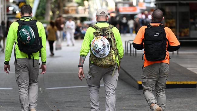 BRISBANE, AUSTRALIA - NewsWire Photos - AUGUST 31, 2022.Construction workers walk through Brisbane's CBD at the end of their work day. Queensland Education Minister Grace Grace has announced a new $10 million pilot program to boost the number of industrial technology and design (ITD) teachers, which will support tradies to become teachers in state schools.Picture: NCA NewsWire / Dan Peled