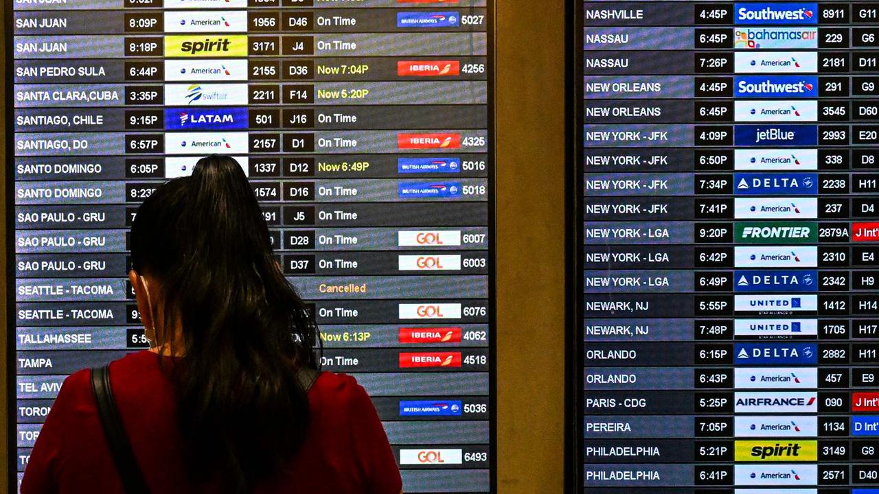 Travellers look at flight schedules at Miami International Airport during a winter storm. (Photo by CHANDAN KHANNA / AFP)