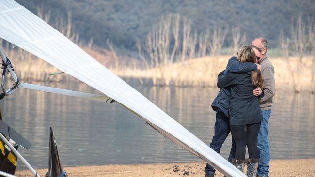 Loved ones embrace beside the lake. Picture: Jason Edwards