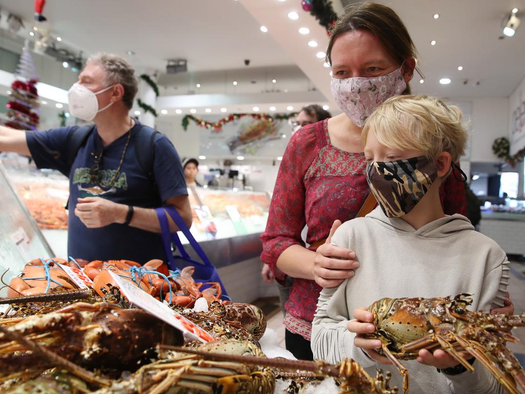 Shopping in masks is the new normal. Nils Woffleben is pictured with his mum Karin at the Sydney Fish Markets checking out the lobsters. Picture: David Swift