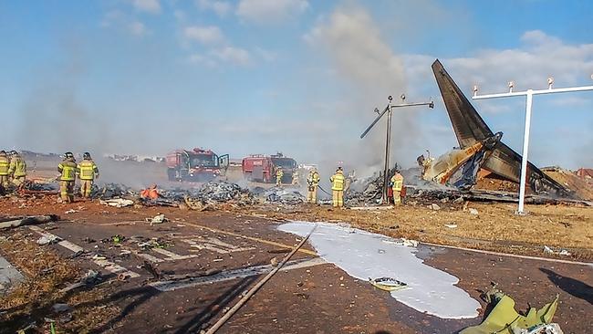 Rescue workers at the crash site in South Korea. Picture: AFP