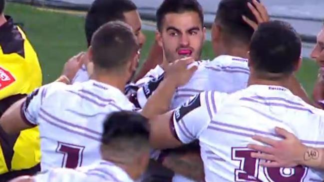 Tom Wright is mobbed by Manly teammates.