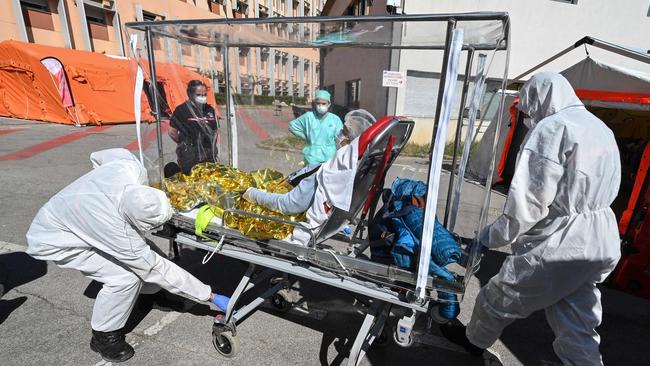 Firefighters unload a patient from their ambulance on a sarcophagus stretcher outside the Montpellier University Hospital, which houses a COVID-19 test centre, in France on Tuesday Picture: AFP