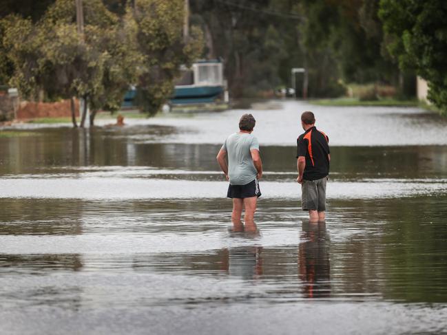 Locals keep watch on the water level. Picture: David Caird