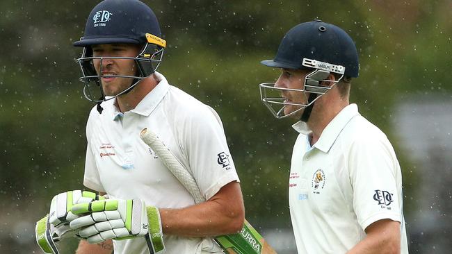 Rob Sayer (left) and Peter Dickson leaving the field after rain hit on Saturday. Picture: Hamish Blair