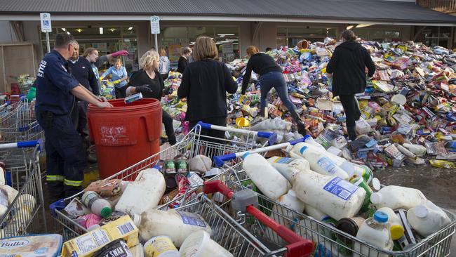 Emergency services staff and volunteers help clean up outside Picton IGA.