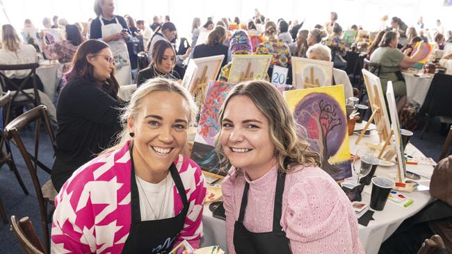 Victoria White (left) and Tammy Thompson participate in the World's Largest Paint and Sip Luncheon for Momentum Mental Health at Clifford Park racecourse, Friday, June 21, 2024. Picture: Kevin Farmer