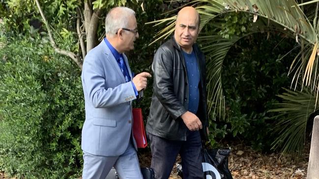 Amini (pictured right) leaving court with his lawyer after sentence