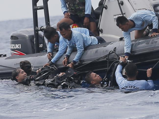 Indonesian navy frogmen emerge from the water during a search operation for the victims of the crashed Lion Air plane in the waters of Tanjung Karawang, Indonesia, Tuesday, Oct. 30, 2018. Divers searched Tuesday for victims of the Lion Air plane crash and high-tech equipment was deployed to find its data recorders as reports emerged of problems on the jet's previous flight that had terrified passengers. (AP Photo/Tatan Syuflana)