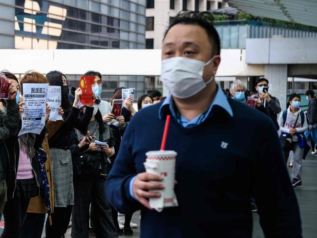 Protesters hold up posters during a "flash mob" gathering to demand the government close its border with mainland China to reduce the spread of the deadly SARS-like virus to Hong Kong on February 3, 2020. - Hundreds of Hong Kong medical workers walked off their jobs on February 3, demanding the city close its border with China to reduce the coronavirus spreading -- with frontline staff threatening to follow suit in the coming days. (Photo by Anthony WALLACE / AFP)