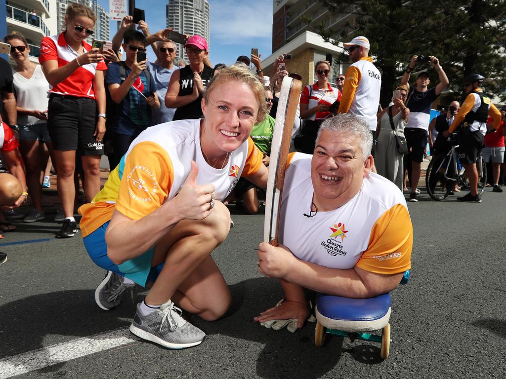 Sally Pearson hands the Queens Baton to disabled former athlete and Gold Coast local John Coutis. Picture: Nigel Hallett