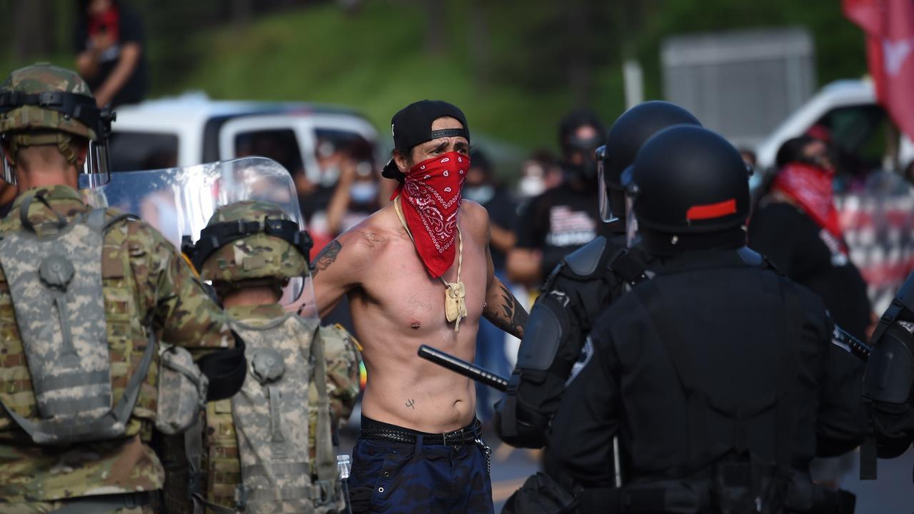 A protester talks to officers on the road outside the Mount Rushmore National Monument. Picture: Andrew Caballero-Reynolds / AFP