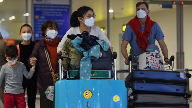 Travellers wearing protective face masks at an airport. Picture: Nhac Nguyen / AFP