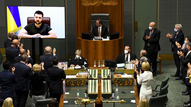 Members of Parliament applaud as Ukrainian President Volodymyr Zelenskiy addresses the House of Representatives via a video link at Parliament House in Canberra on Thursday. Picture: AAP