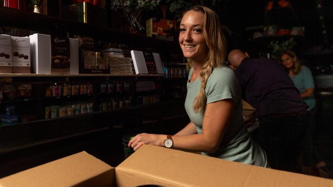 Heather Haines from Parap Fine Foods moves perishable items from the business’ in-store fridge to back-up fridge to save stock. Picture: Che Chorley