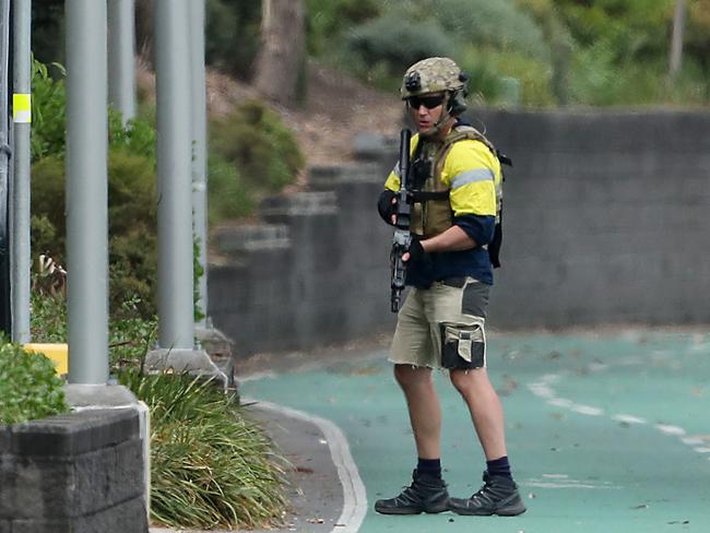 A SERT officer with machine gun guards the bike way along the Brisbane River near the Wesley Hospital, Auchenflower. Photographer: Liam Kidston.