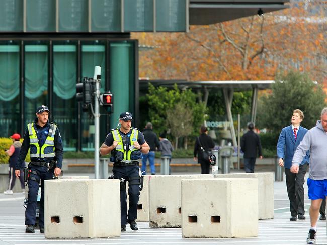 Police officers walk past concrete bollards on Southbank. Picture: Mark Stewart