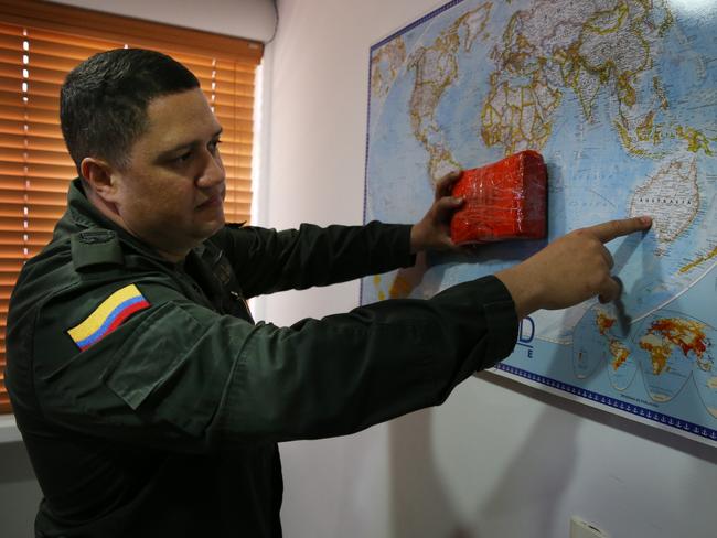 Commander of the Cartagena Police National Narcotics Devision's Colonel Jorge Villarroel with a slab of cocaine as he points out the traffickers likely routes to Australia. Picture: Gary Ramage