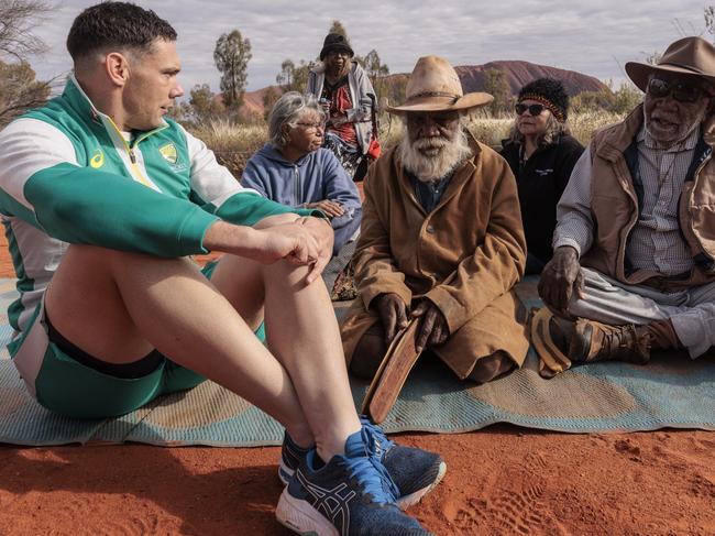 ULURU, AUSTRALIA - AUGUST 09: Scott Boland sits with local elder during the T20 World Cup Trophy Tour at Uluru on August 09, 2022 in Uluru, Australia. The T20 World Cup World Cup Trophy will travel across four continents before it returns to Geelong on 16th October, right before the tournament starts. (Photo by Brook Mitchell/Getty Images)