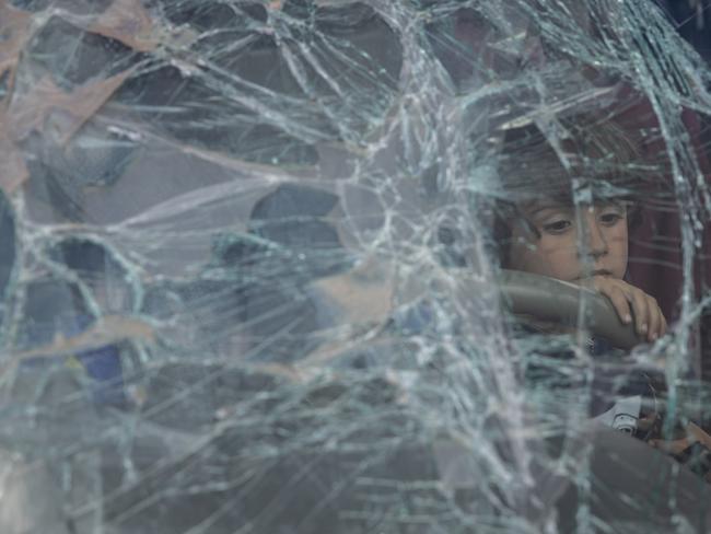 A boy from Mariupol looks through the smashed windscreen of his family's car after arriving at an evacuation point for people fleeing Mariupol, Melitopol, towns under Russian control. Picture: Getty Images