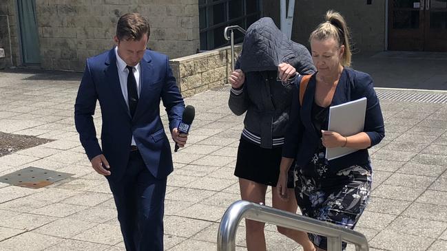 A teacher (centre) who can only be identified as `DE' leaves Toronto Local Court. Picture: Richard Noone