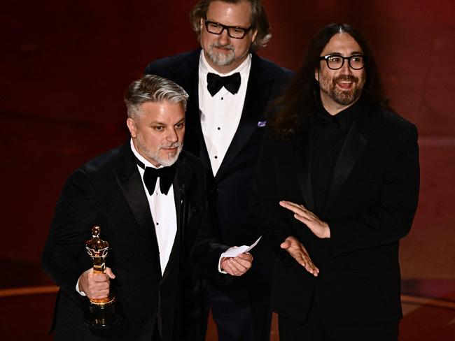 US writer and director Dave Mullins (C), US producer Brad Booker (L) and US musician Sean Ono Lennon accept the award for Best Animated Short Film for "War is Over!. Picture: AFP