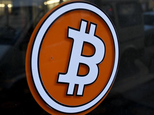 (FILES) This file photograph taken on January 8, 2021, shows a Bitcoin digital currency logo on the front door of an ATM in Marseille, southern France. - Bitcoin's value plunged on May 19, 2021, after China signaled a new crackdown on the cryptocurrency, but its losses were cushioned after Tesla head Elon Musk spoke up on Twitter. The virtual currency fell to almost $30,000 -- less than half the record value it reached last month -- before climbing back over $39,500 around 2000 GMT. It was still above its level at the start of the year. Bitcoin recovered somewhat following tweets from Musk that featured a diamond and hands emoji, taken as a signal the company had not sold off its huge bitcoin holdings as the CEO appeared to suggest recently. (Photo by NICOLAS TUCAT / AFP)