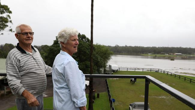 Reg and Lorraine Smith look on as the Hawkesbury River rises at McGraths Hill, Sydney. The Smiths are determined to ride out this flood, but they concede evacuating could be their only option. Picture: Jane Dempster