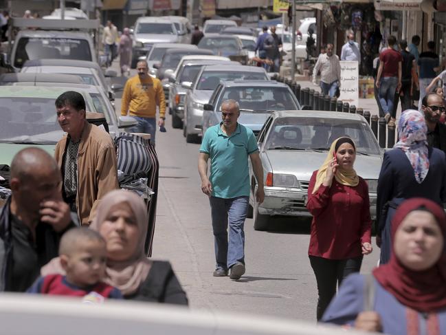 People walk on the main street in Karak, Jordan, after a curfew was lifted for some southern cities, amid concerns about the coronavirus Wednesday, April 22, 2020. Jordan on Wednesday eased movement restrictions in three large and sparsely populated southern districts where no coronavirus cases have been reported. Life began returning to normal in the districts of Karak, Maan and Tefileh. (AP Photo /Raad Adayleh)