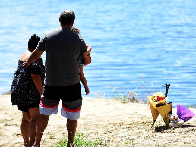 Bodies of the two boys who went missing in Cranbrook, Townsville, were found in the Ross River. Serena Saltner leaves flowers by the scene. Picture: Alix Sweeney