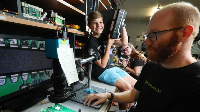 Harry Green, 15 of Jimboomba with his refurbished computer with Kayla Poulter and Jesse Pullen, who are part of a team of volunteer computer technicians building PCs for Queensland kids in need. Photographer: Liam Kidston