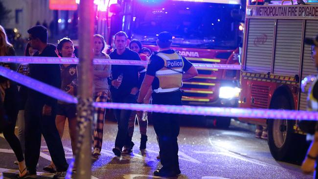 Pedestrians avoid police tape after a Southbank apartment complex flooded on Sunday night. Picture: Patrick Herve