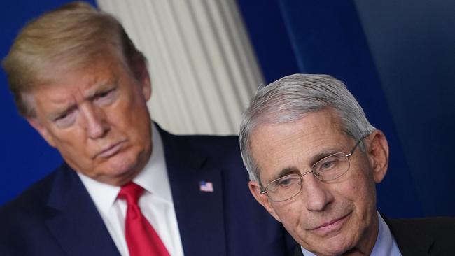 Director of the National Institute of Allergy and Infectious Diseases Anthony Fauci, flanked by US President Donald Trump.