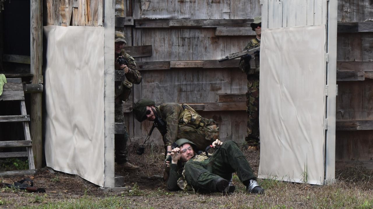 OPERATION TEMPEST: A PLAM player drags his comrade to safety during Operation Tempest on the Fraser Coast. Photo: Stuart Fast