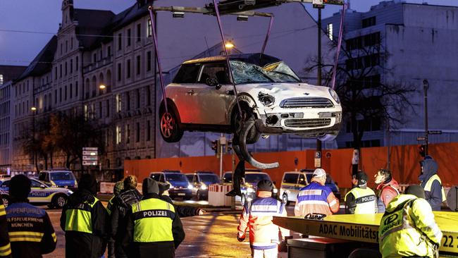 The car is lifted by crane on to a tow truck at the scene. Picture: Matthias Balk / AP