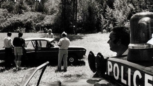 Detectives from Lismore and Sydney examine the car that was found beside the body of victim Jeffrey Parkinson.