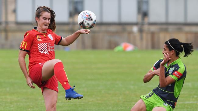 Adelaide’s Julia Ashley kicks over Canberra opponent Leena Khamis. Picture: Mark Brake/Getty Images