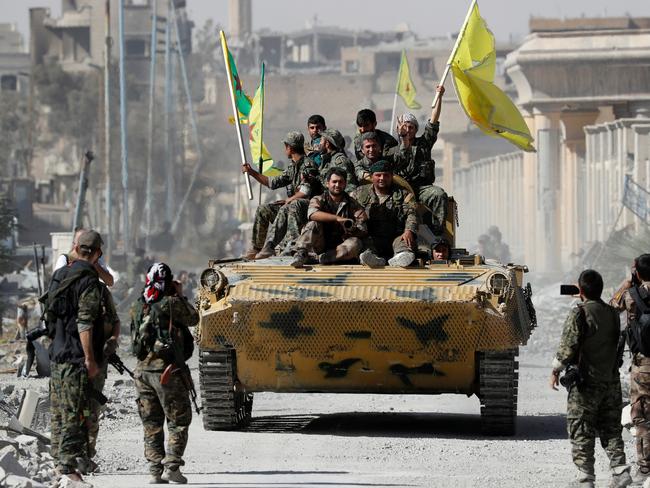 Fighters of Syrian Democratic Forces ride atop of an armoured vehicle after Raqqa was liberated from the Islamic State militants, in Raqqa, Syria.  Picture:  Reuters