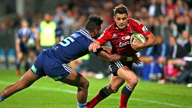 Dan Carter of the Crusaders is tackled by Lolagi Visinia of the Blues.