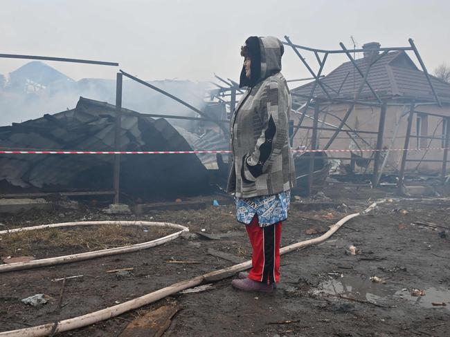 TOPSHOT - A local resident reacts as she looks at her neighbours' house, which was destroyed in a drone strike in Kharkiv, on December 25, 2024, amid the Russian invasion in Ukraine. The Ukrainian president on December 25 denounced as an "inhumane" attack from Russia, which launched over 170 missiles and drones on his war-torn country's power grid on Christmas Day, killing one and causing widespread blackouts. The country woke up at 5:30 am (0330 GMT) to an air raid alarm, shortly followed by air force reports that Russia had launched Kalibr cruise missiles from the Black Sea. (Photo by SERGEY BOBOK / AFP)