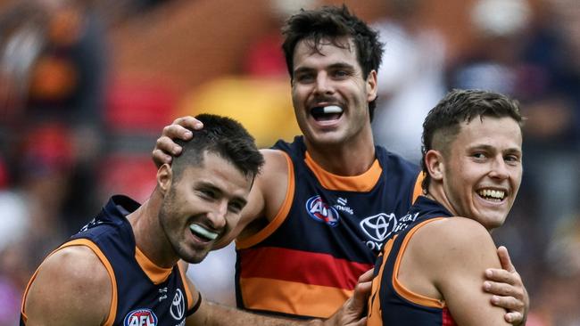 ADELAIDE, AUSTRALIA - MARCH 16: Jake Soligo of the Crows celebrates a goal  with Alex Neal-Bullen and Darcy Fogarty of the Crows during the round one AFL match between Adelaide Crows and St Kilda Saints at Adelaide Oval, on March 16, 2025, in Adelaide, Australia. (Photo by Mark Brake/Getty Images)