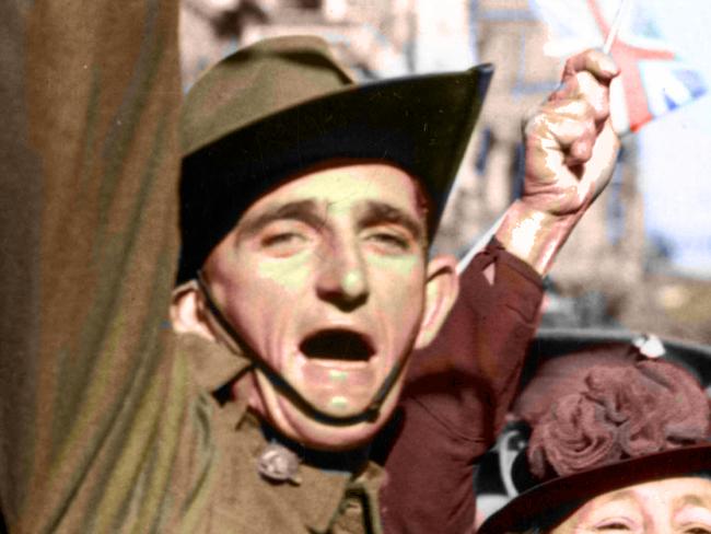 Colourised 15 Aug 1945. Although discharged in /1944 the man, ex- V301056 Pte Melbourne Bourke Saunders donned his uniform and travelled into the city to take part in the celebrations for VJ / VP Day - crowd lining Swanston Street waving flags and throwing streamers. WWII Pic/AWM Neg 181808 (NOT TO BE REPRODUCED WITHOUT PERMISSION). history Vic