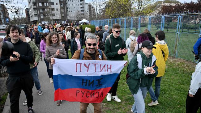 Peter Nikitin, a Russian pro-democracy activist, holds a Russian flag with writting reading "Putin is not Russia" outside a polling station set up in a Russian Embassy School on the day of Russia's presidential election, in Belgrade. Picture: Oliver Bunic/AFP